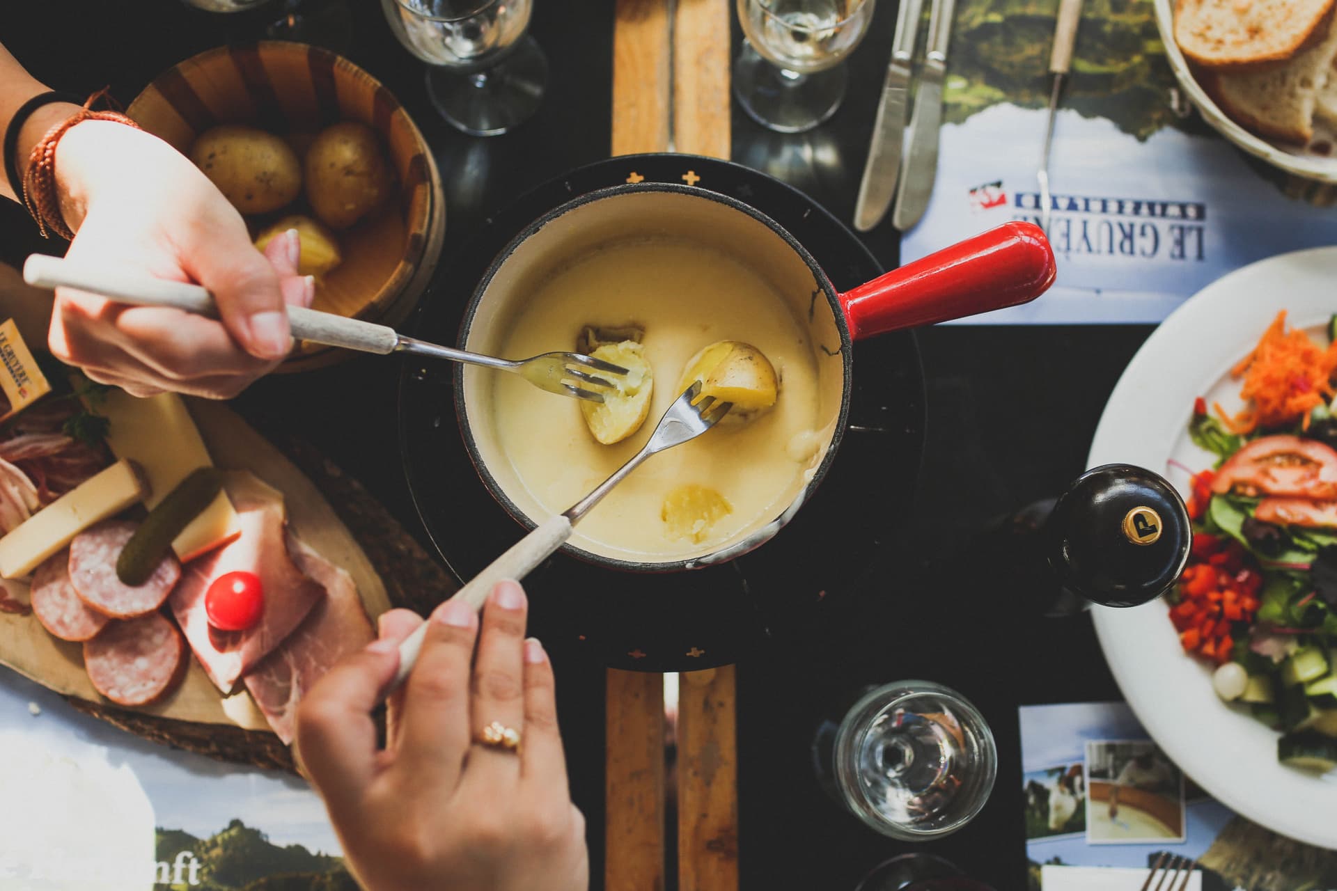 Family enjoying eating fondue cheese while on holiday in france